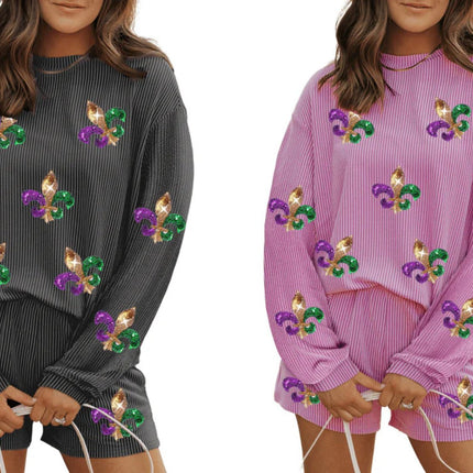 Two Mardi Gras two-piece jogger sets—one in carbon grey and one in pink—featuring sparkling Fleur-de-Lis embellishments. Perfect for carnival celebrations and festive outfits